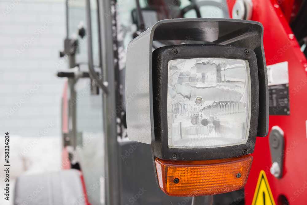 Headlight of tractor, red agricultural vehicle