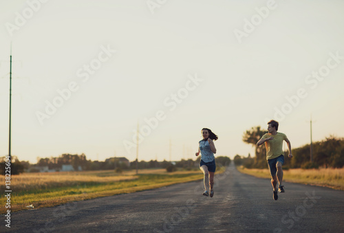 young sport  woman and her husband running on the broad road
