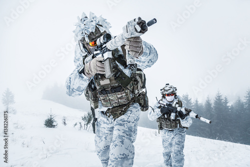 Winter arctic mountains warfare. Action in cold conditions. Pair of special forces weapons in forest somewhere above the Arctic Circle, low angle view