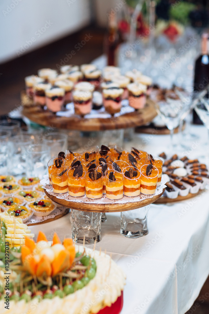 The tiramisu,fruits and jellies  stand on the buffet table