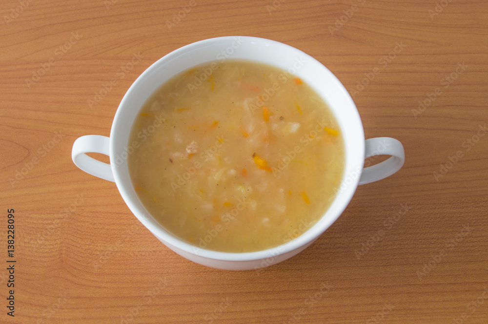 Polish cabbage soup in a white bowl on wooden background. Soup knows in Poland as Kapusniak. Polish cabbage soup in a white bowl on wooden background. Soup knows in Poland as Kapusniak.