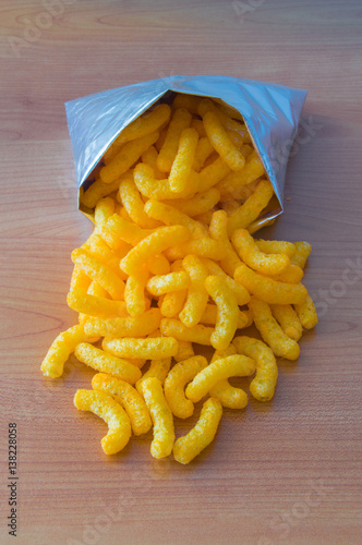 Corn puff snack in bag on wooden background. photo