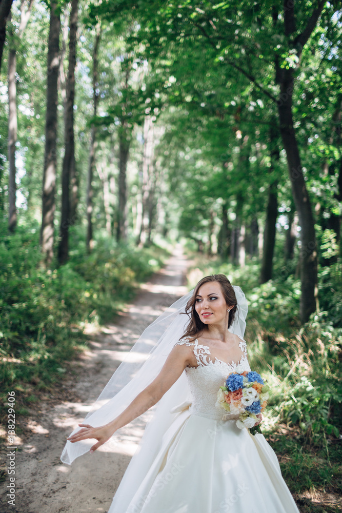 The beautiful bride keeps a bouquet in the park The beautiful bride keeps a bouquet in the park