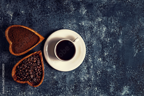 Coffee cup, beans and ground powder on stone background. 