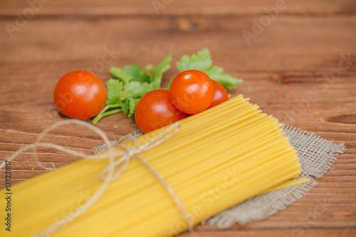 На столе лежат спагетти с помидорами.