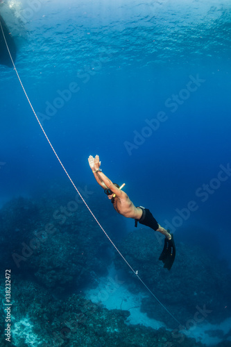 Freediver ascending up a line from deep water
