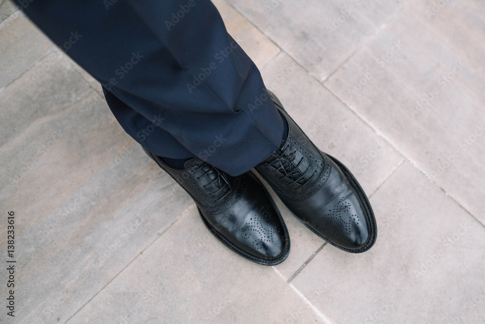 the groom's legs in black leather and beautiful shoes the groom's legs in black leather and beautiful shoes