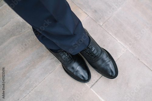 the groom's legs in black leather and beautiful shoes © myronovychoksana