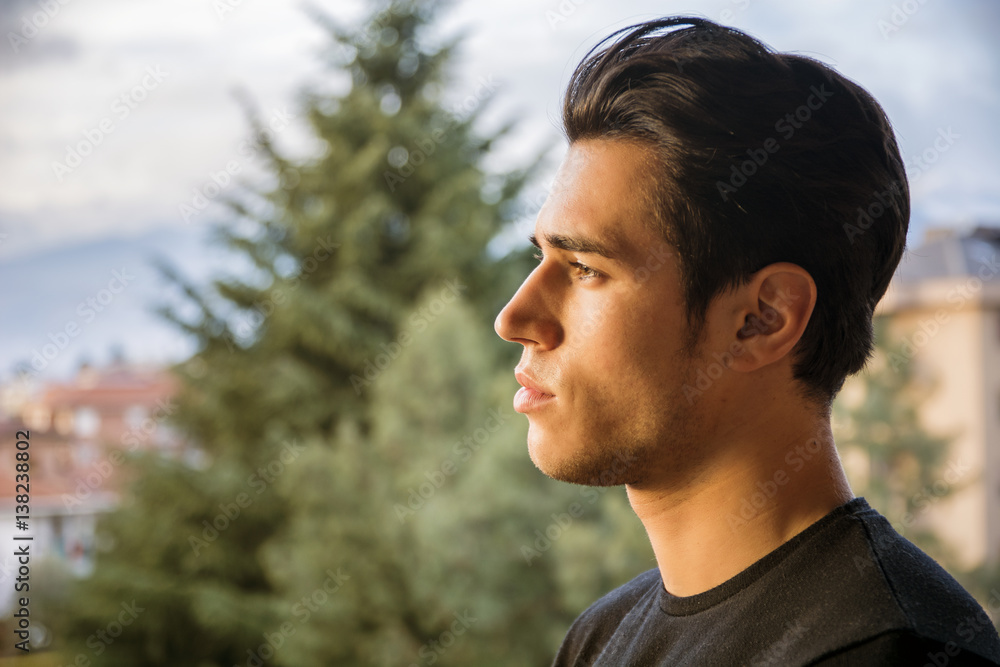 Profile headshot of handsome attractive young man outdoor, looking to a side Profile headshot of handsome attractive young man outdoor, looking to a side