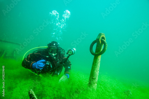Taucher mit versunkenem Anker in Unterwasserlandschaft photo