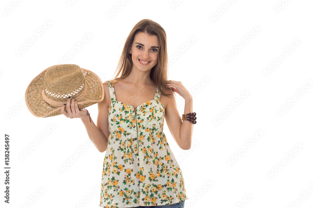 Happy brunette woman in sarafan with floral patter and straw hat posing and smiling on camera isolated on white background Happy brunette woman in sarafan with floral patter and straw hat posing and smiling on camera isolated on white background