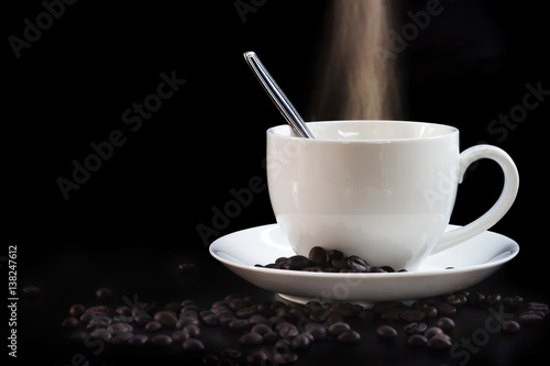 Hot cup of coffee in white on a dark background.
