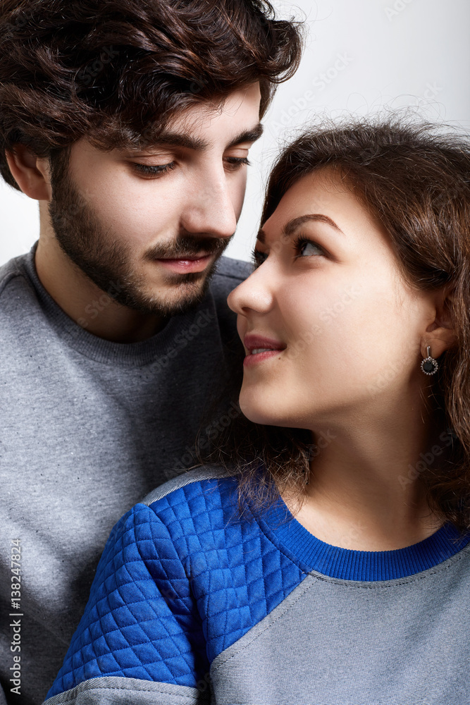 Close-up of young hipster couple standing close to each other looking with love and sensuality. Young affectionate couple looking at one another. Family and relationships concept. Close-up of young hipster couple standing close to each other looking with love and sensuality. Young affectionate couple looking at one another. Family and relationships concept.