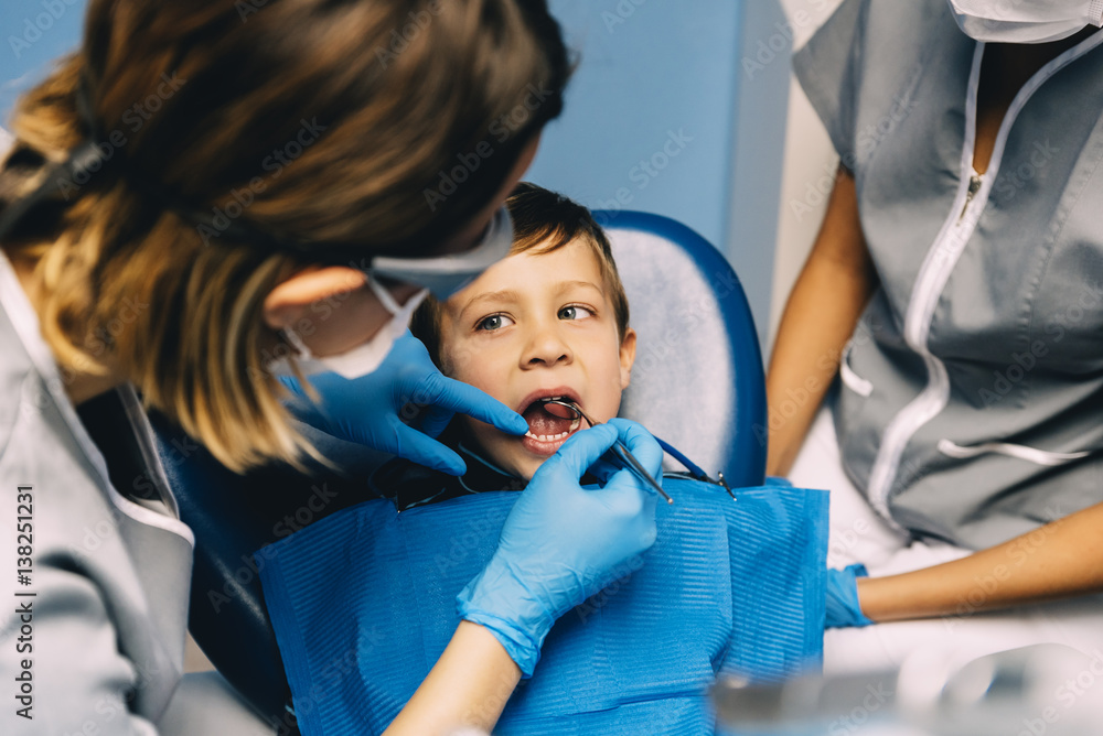 Dentists with a patient during a dental intervention to boy. Dentists with a patient during a dental intervention to boy.