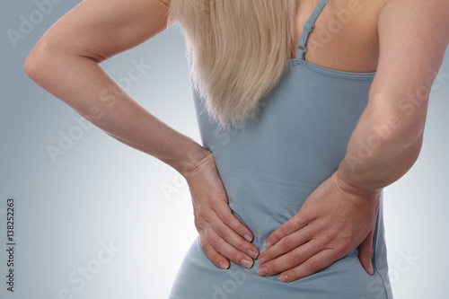 Wallpaper Mural Back Pain. Athletic fitness woman rubbing the muscles of her lower back. Sports exercising injury. Torontodigital.ca