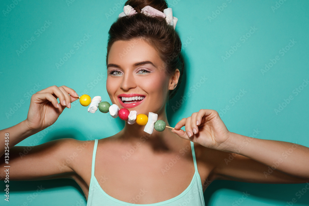 Happy woman with colorful makeup and sweet candies on skewer Happy woman with colorful makeup and sweet candies on skewer