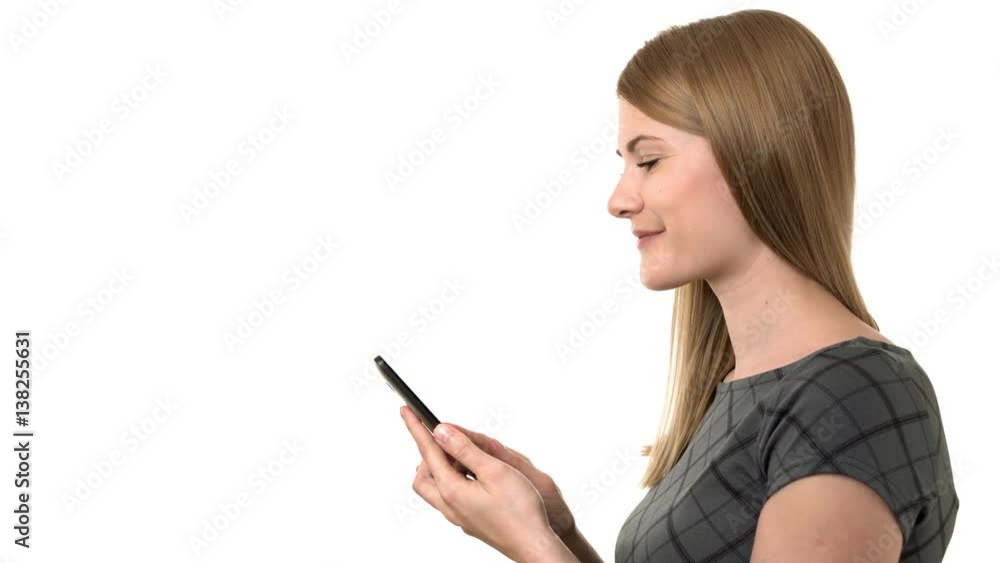 Beautiful businesswoman in grey dress working on her smartphone. Isolated white background. Beautiful businesswoman in grey dress working on her smartphone. Isolated white background.