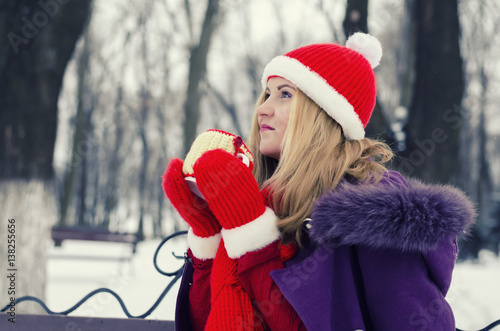 Girl with a cup of hot beverage outdoors in winter photo