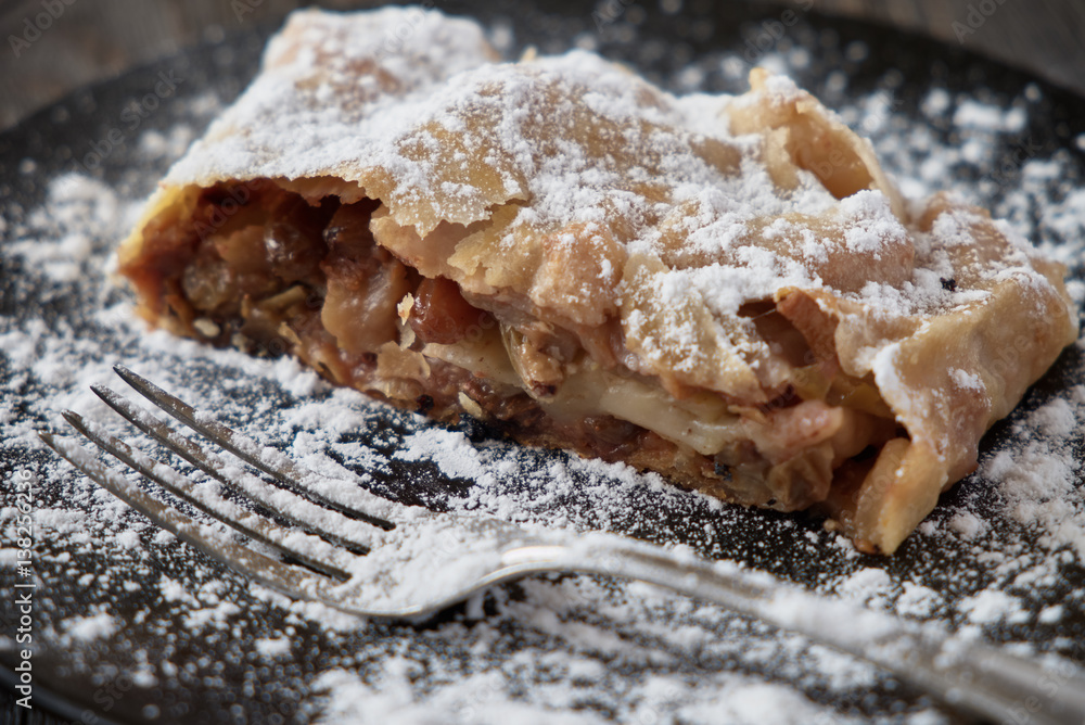 Fototapeta premium Fresh baked homemade apple strudel with powdered sugar