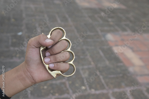 Hand man wearing brass knuckles