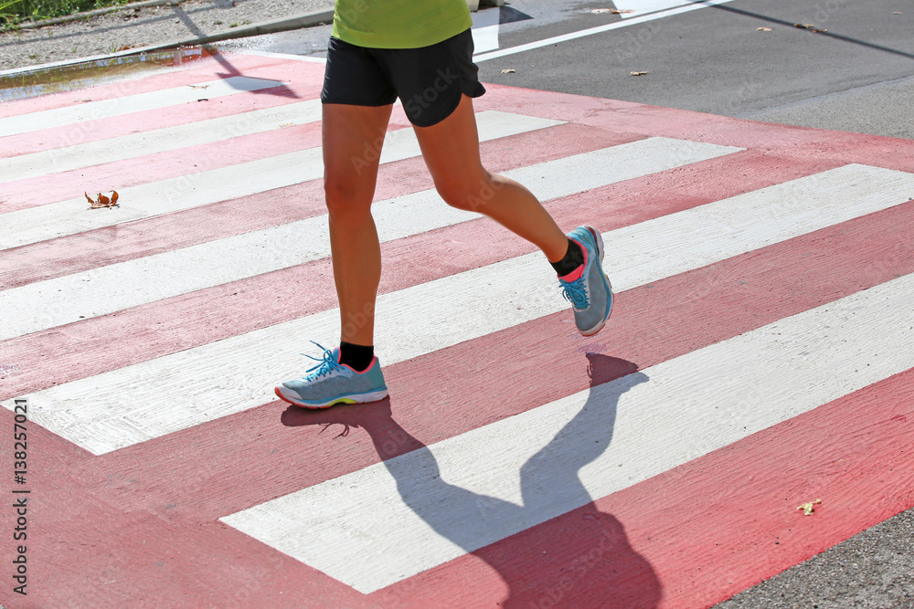marathoner runs fast over the pedestrian crossing in the city