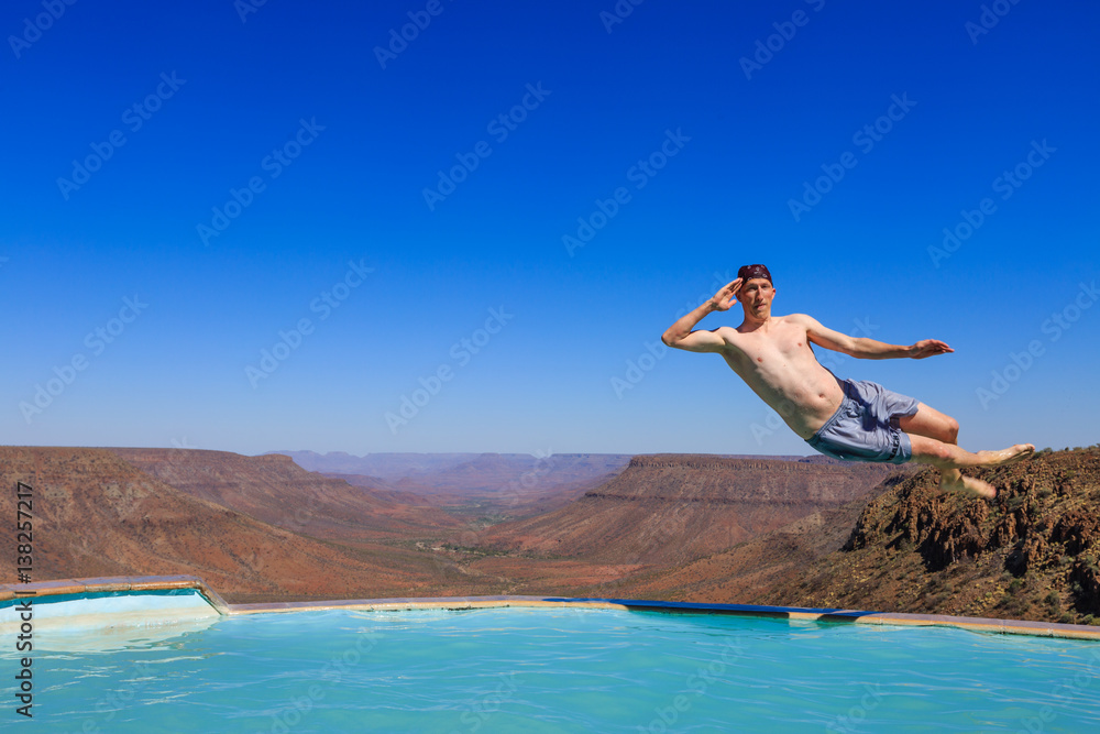 Junger Mann springt in Pool, Grootberg Lodge, Grootberg, Region Kunene Junger Mann springt in Pool, Grootberg Lodge, Grootberg, Region Kunene