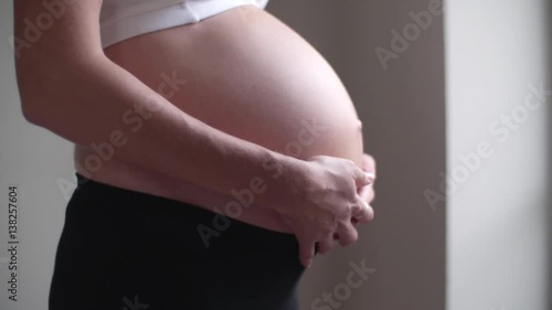 Close-up of pregnant woman rubbing her bare stomach