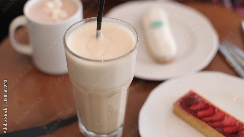 Coffee Cup and Eclairs on a Wooden Table Coffee Cup and Eclairs on a Wooden Table
