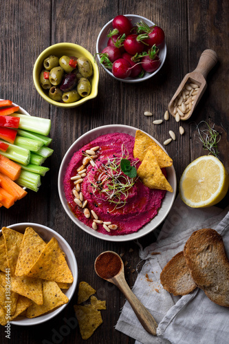 Homemade roasted beet root hummus served with variety of snacks; Overhead view