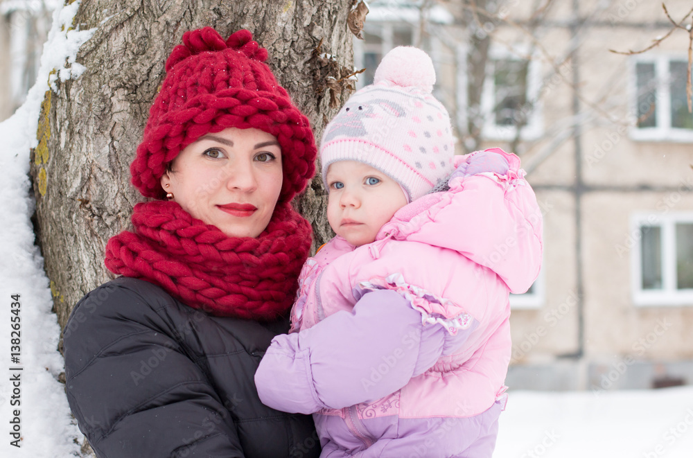 Beautiful mom and nice baby outdor in a winter
