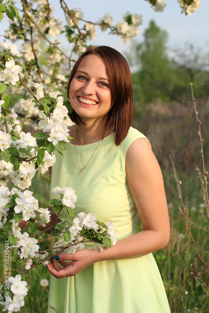 Young smiling girl standing near the apple tree Young smiling girl standing near the apple tree