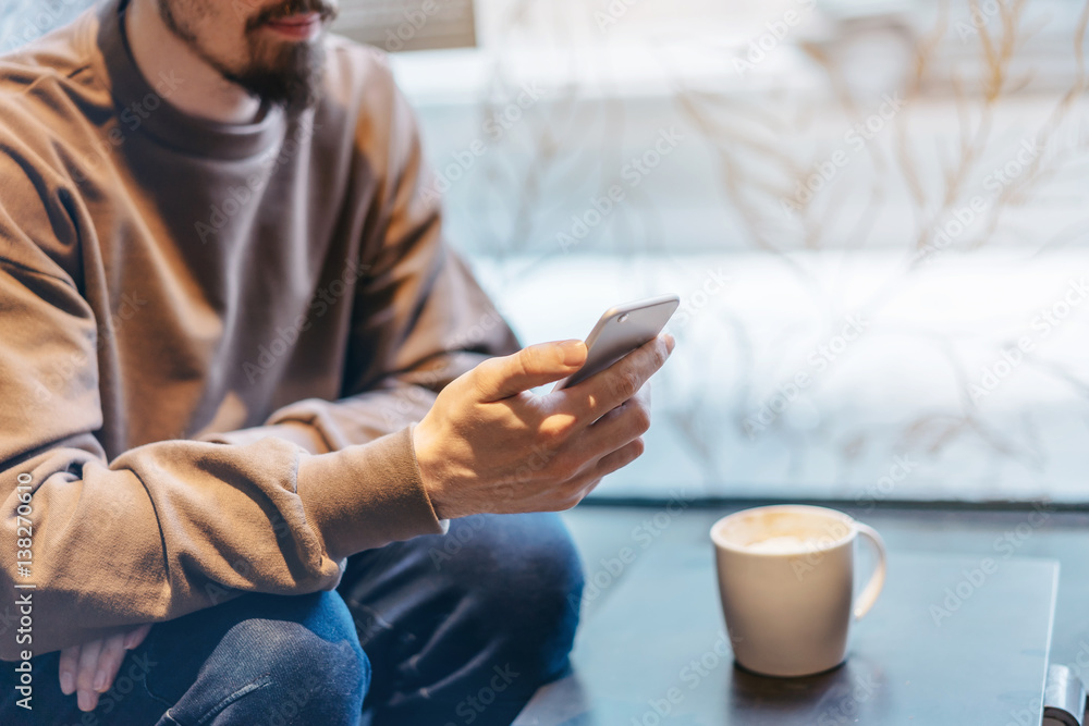 Young freelance manager checking new messages from employer, Attractive man drinking coffee after hours, blurred background, shallow DOF Young freelance manager checking new messages from employer, Attractive man drinking coffee after hours, blurred background, shallow DOF