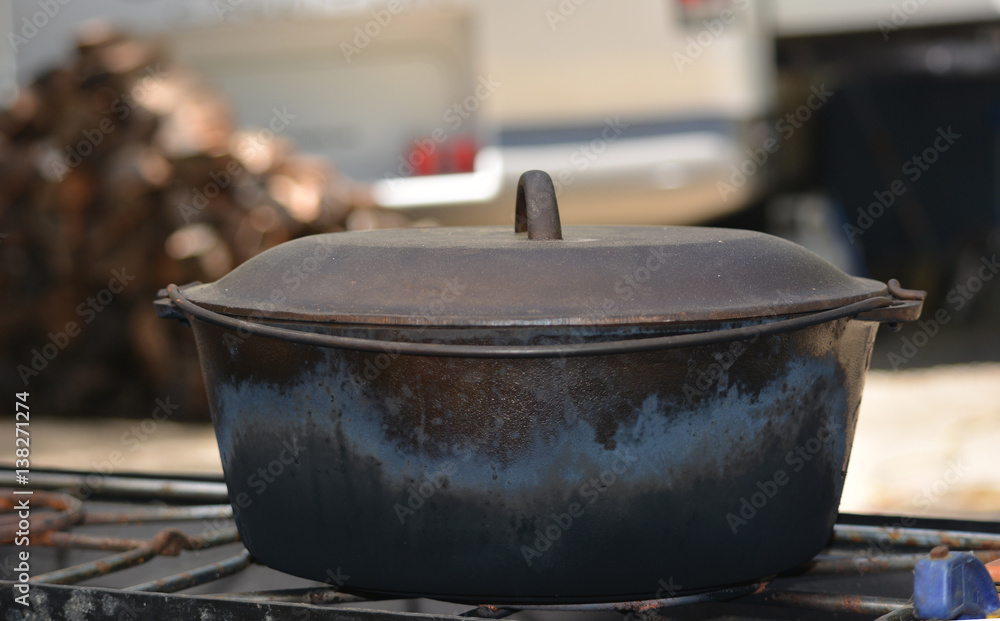 Cast Iron Dutch Oven In Front of Wood Pile Cast Iron Dutch Oven In Front of Wood Pile
