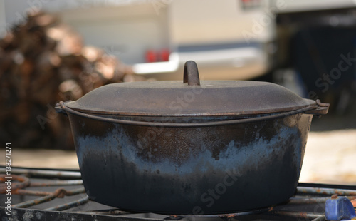 Cast Iron Dutch Oven In Front of Wood Pile
