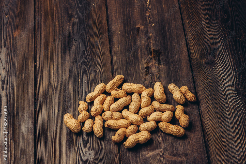 peanut in a shell on a wooden background peanut in a shell on a wooden background