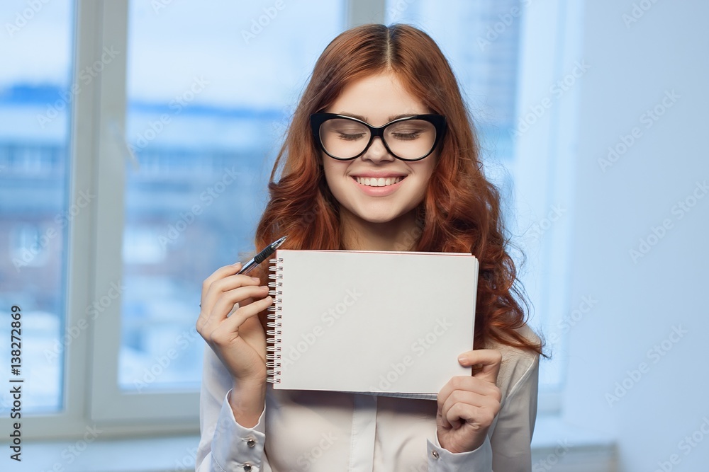 smiling woman looking at a notebook on a window background smiling woman looking at a notebook on a window background