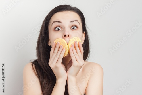 an amazed brunette covers her mouth with sponges