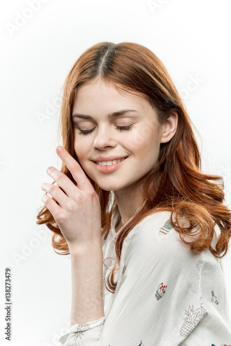 a woman with her eyes closed removes her hair from her face