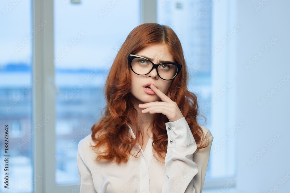 red-haired woman in glasses stands indoors red-haired woman in glasses stands indoors
