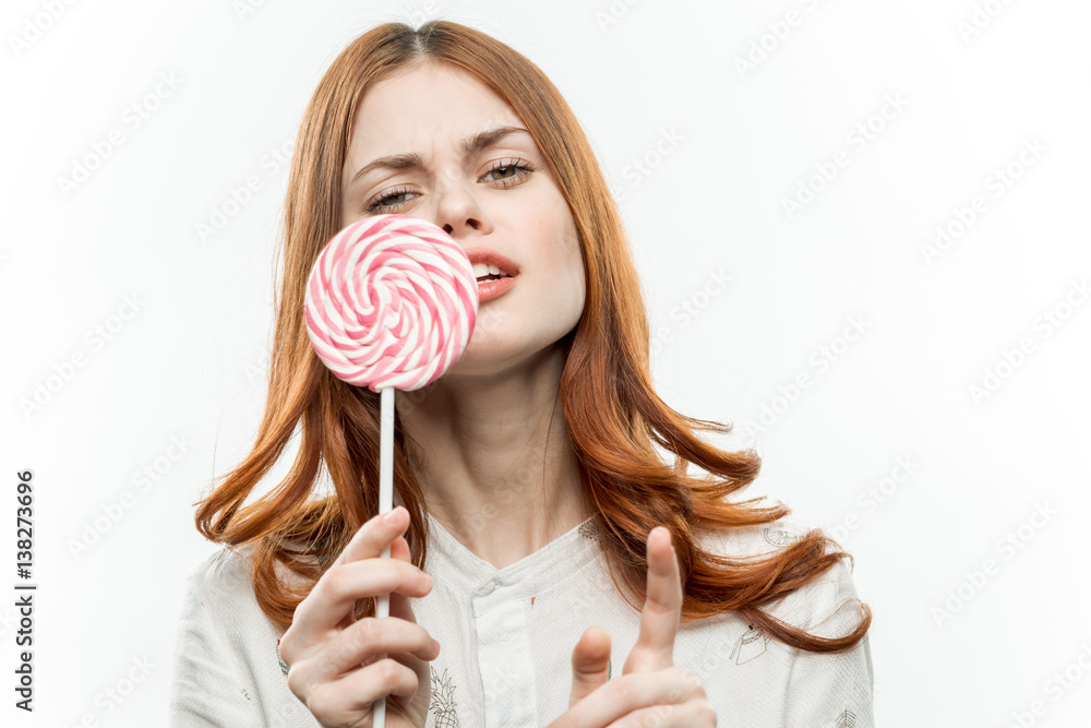 woman holding a round candy in front of her face