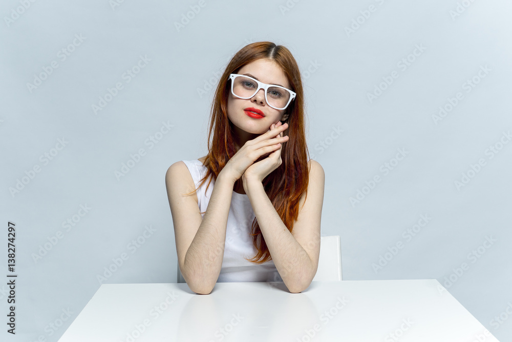 the woman at the table in glasses folded her hands near the head the woman at the table in glasses folded her hands near the head