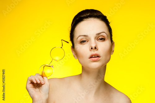 woman holding glasses, yellow background