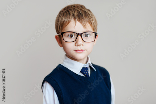 Portrait of schoolboy with glasses on white background