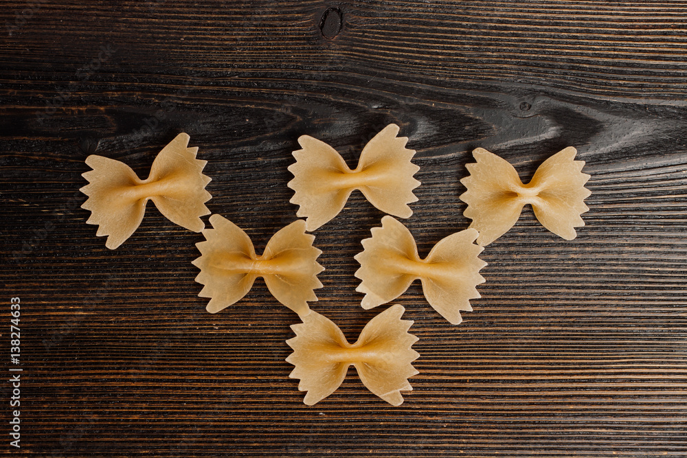 vermicelli in the form of bows on a wooden table vermicelli in the form of bows on a wooden table