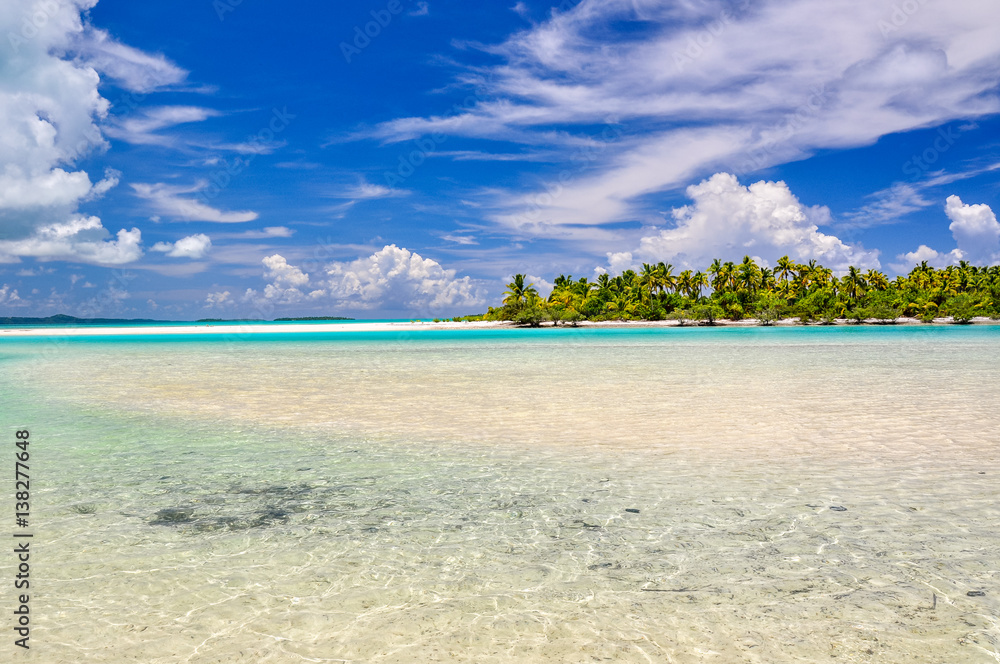 Stunning view of a beach on One Foot Island, also called Tapuaetai, in the lagoon of Aitutaki, Cook Islands, in the South Pacific Ocean. Clear water, palm trees and white sand beach on a sunny day. 