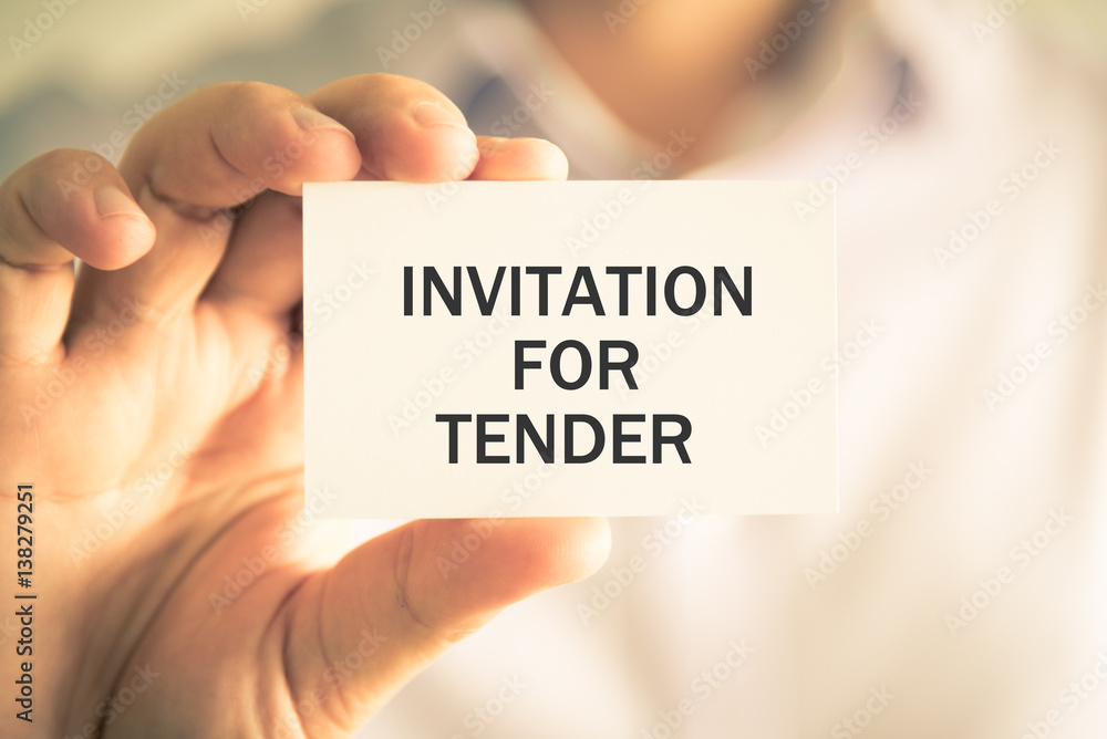Businessman holding INVITATION FOR TENDER message card Businessman holding INVITATION FOR TENDER message card