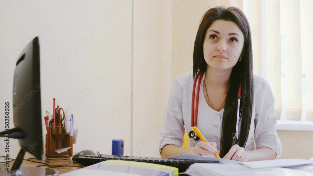Female doctor doing paperwork in the office. Young therapist filling medical checklist sitting at the desk. Health care and insurance concept. Female doctor doing paperwork in the office. Young therapist filling medical checklist sitting at the desk. Health care and insurance concept.