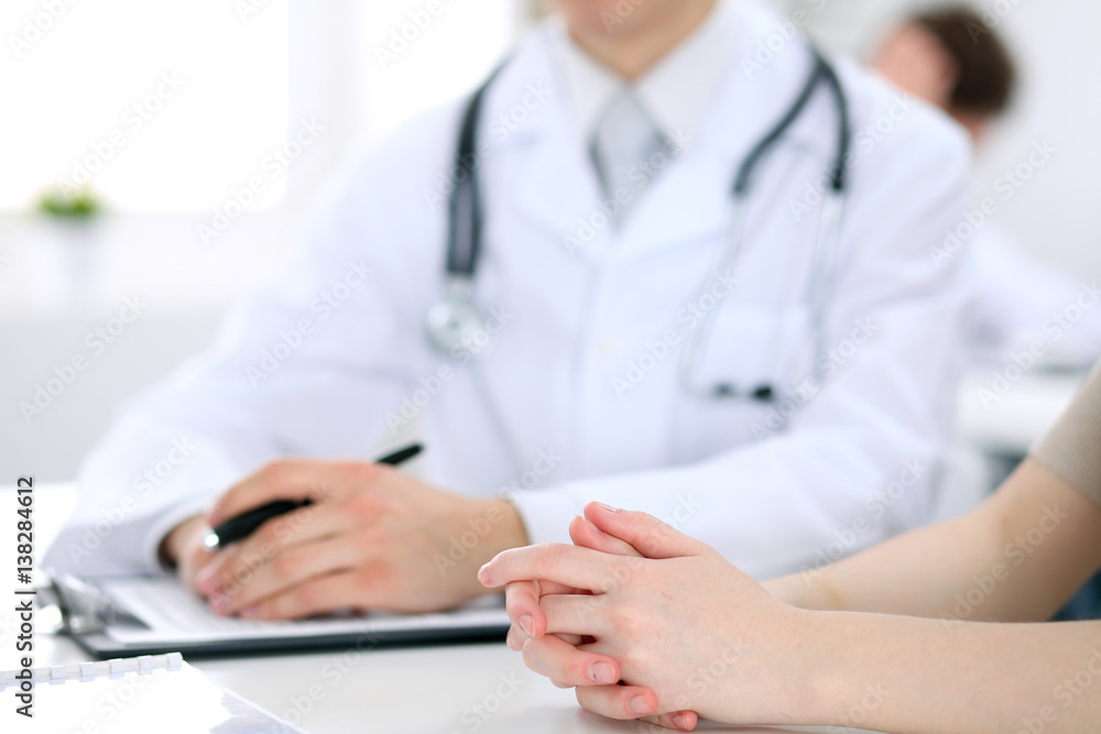 Doctor and patient are discussing something, just hands at the table Doctor and patient are discussing something, just hands at the table