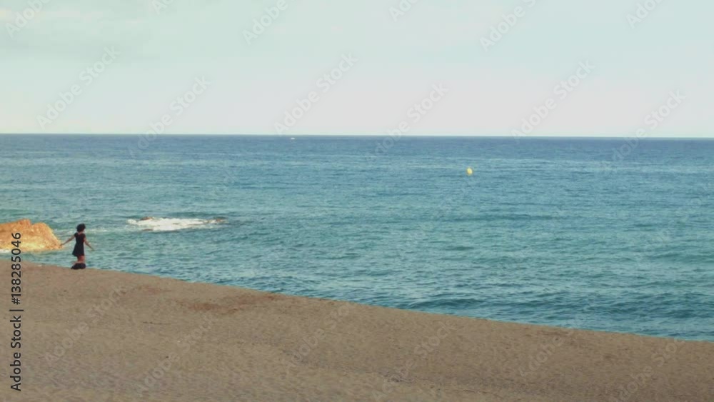 Woman is happy at the beach - wide establishing shot Woman is happy at the beach - wide establishing shot