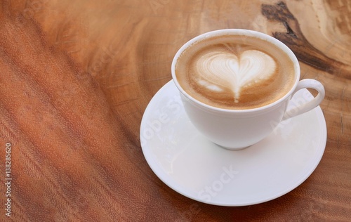 Top view of hot coffee latte art heart shape foam on wood table background